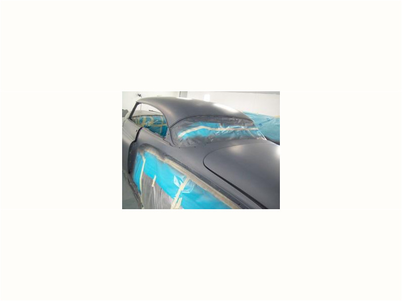 Here's a short alt tag for the image: `Gray classic car in paint booth`
