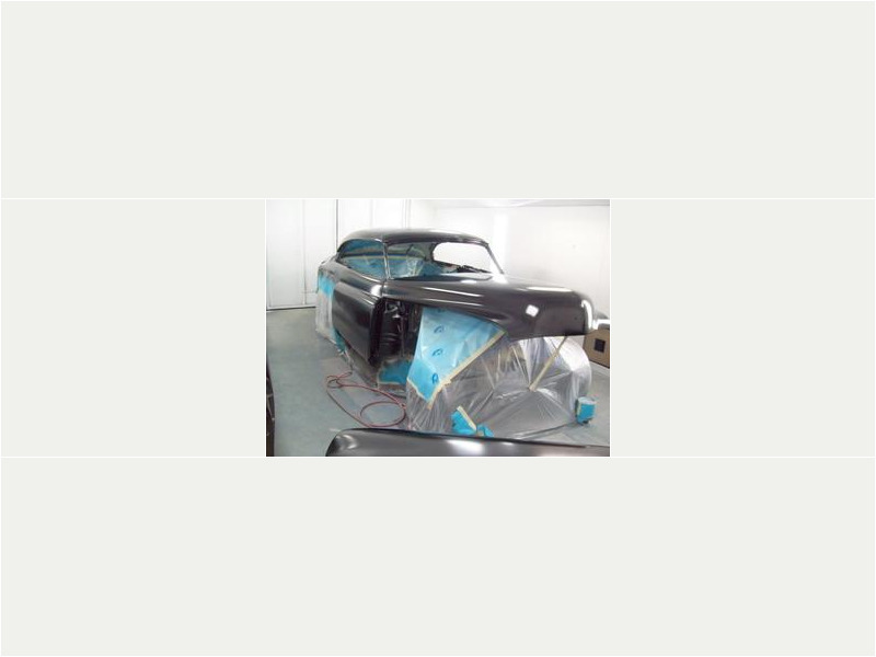 Here's an alt tag for the image: `Classic car in progress, body shop`