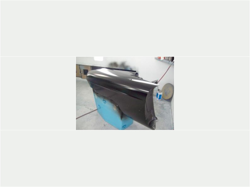 Here's an alt tag for the image: `Black car fender, freshly painted.`