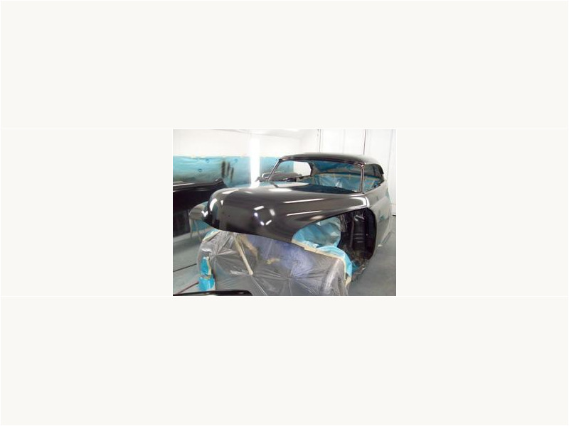 Here's an alt tag for the image: Black classic car in progress.