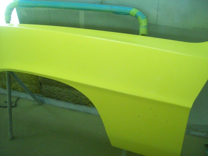 Bright yellow car fender, freshly painted.