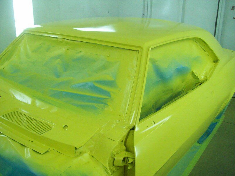 Yellow classic car in paint booth.