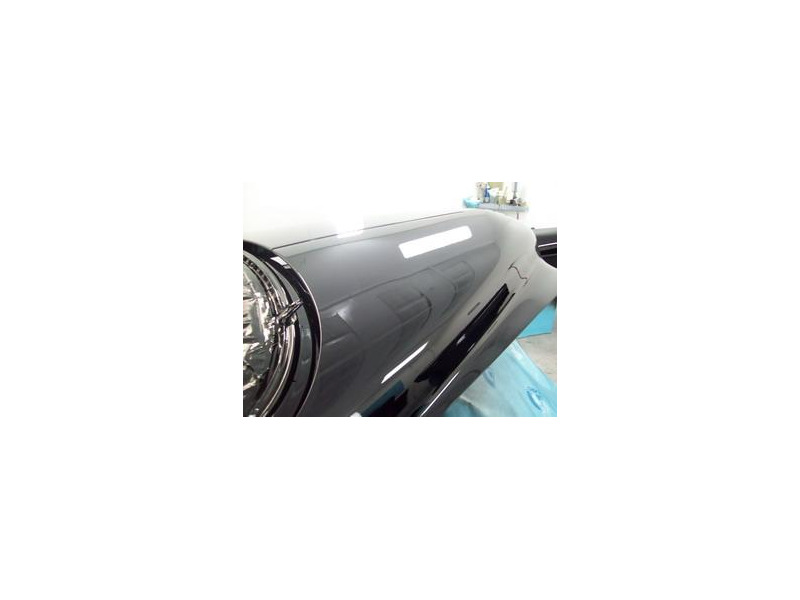 Here's an alt tag for the image: Black car hood, freshly painted.