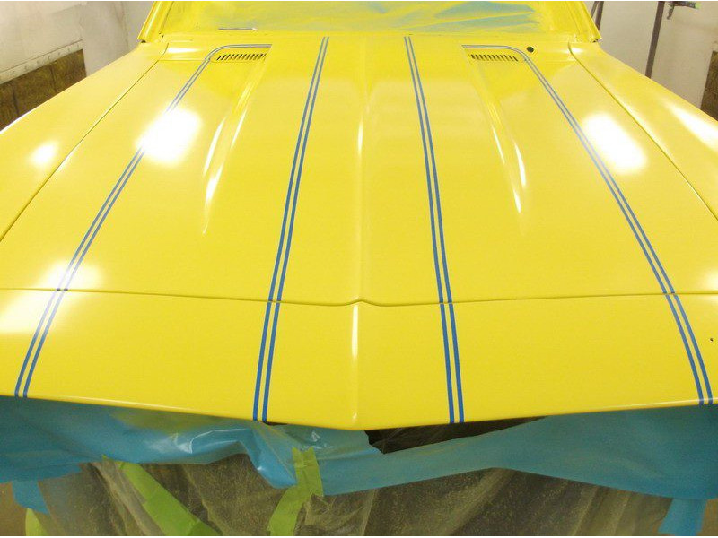 Yellow car hood with blue stripes.