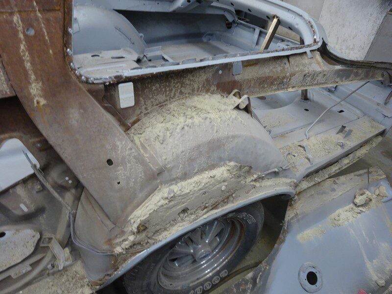 Rusty car body undergoing restoration.
