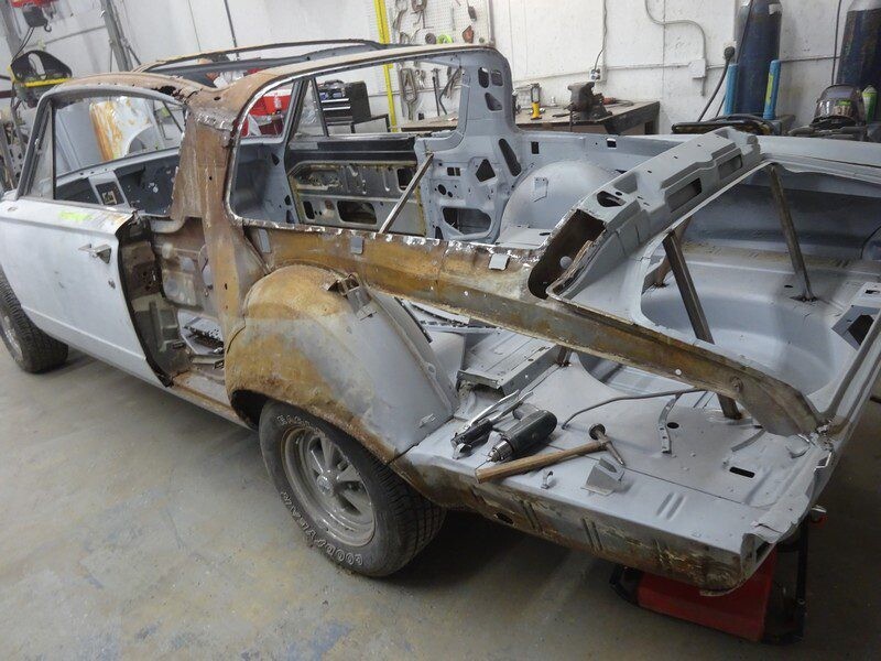 Rusting classic car undergoing restoration.