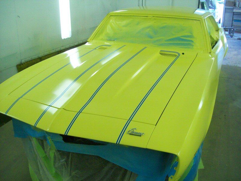Yellow Camaro freshly painted with stripes.