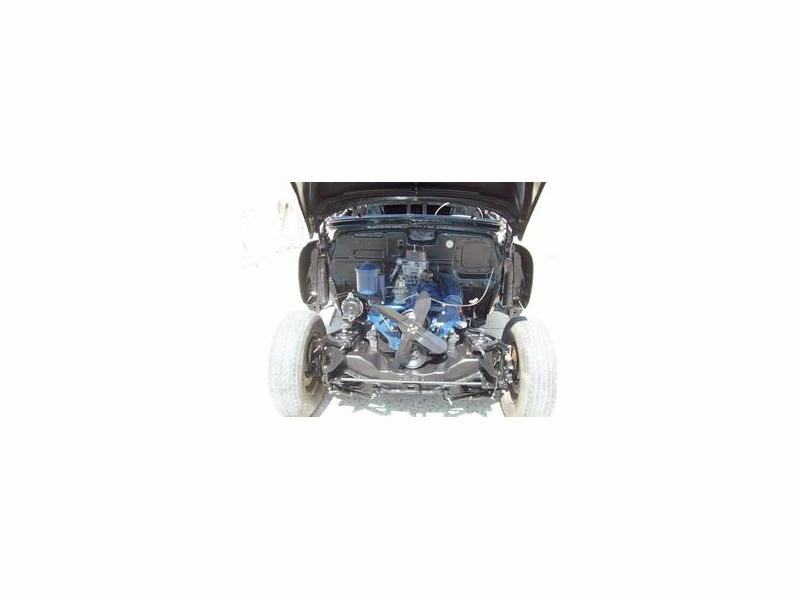Here's an alt tag for the image: Black classic car engine detail.