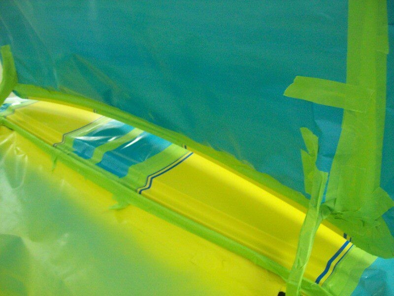Car body being painted, masked off.