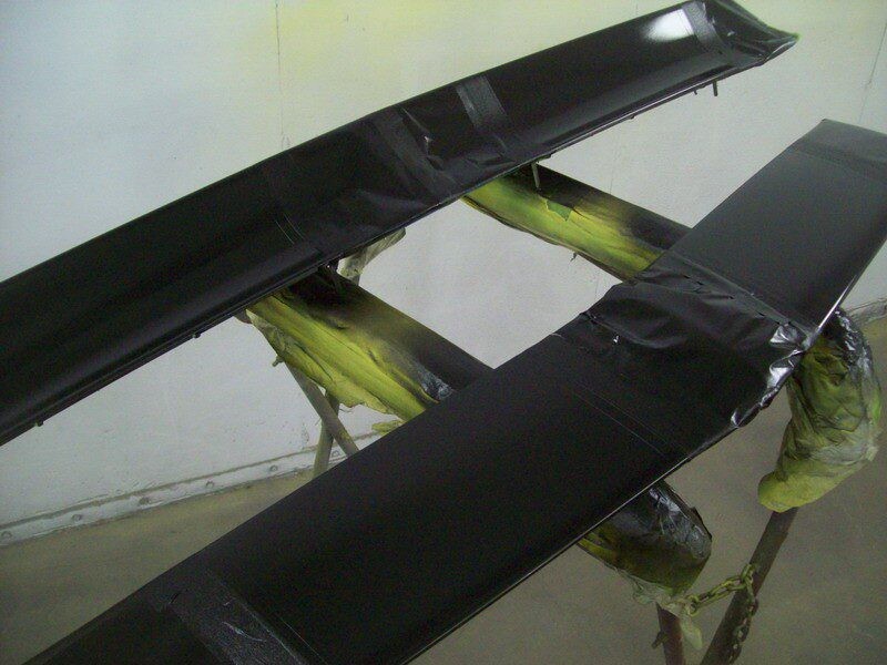 Black car spoiler being painted.