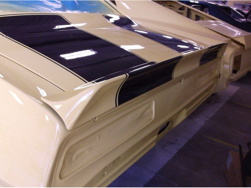 Beige car rear with black stripes.