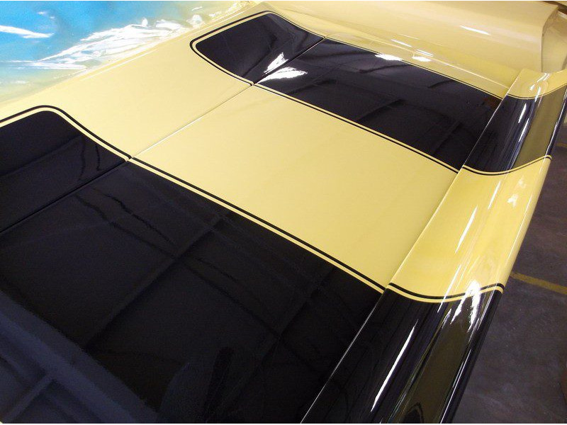 Yellow car with black racing stripes.