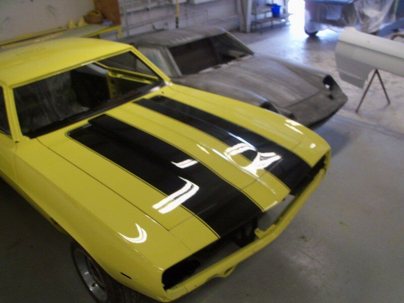 Yellow Camaro with black racing stripes.
