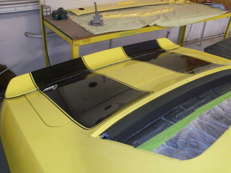 Yellow Camaro with black racing stripes.
