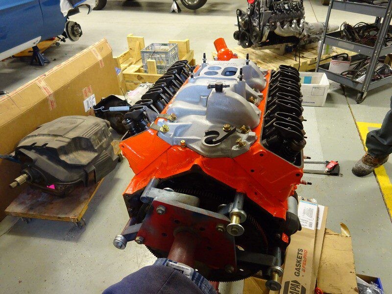 Orange V8 engine block on workbench.