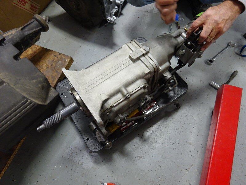 Mechanic repairing a car transmission.