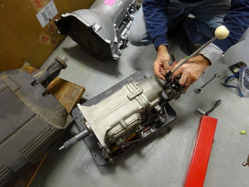 Mechanic installing car transmission parts.