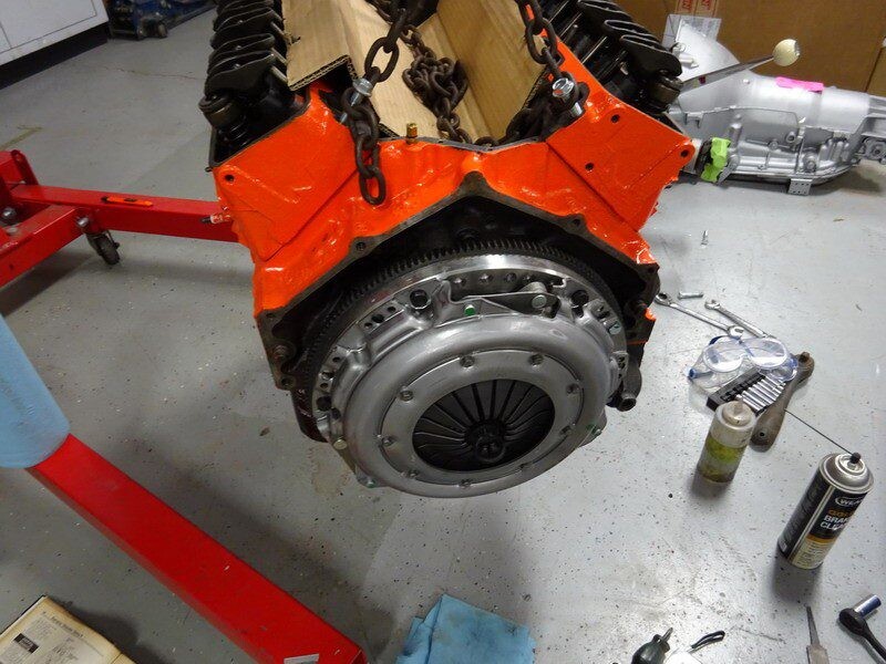 Orange engine block with clutch installed.