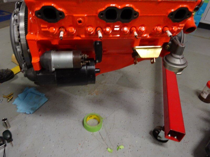 Orange engine block with starter motor.