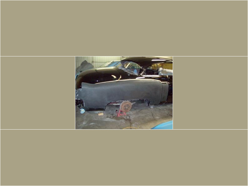 Here's an alt tag for the image: Black classic car undergoing restoration.