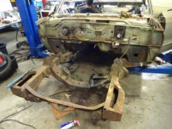 Rusting car frame in auto shop.