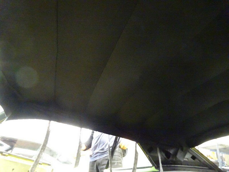 Car headliner, dark fabric, needs repair.