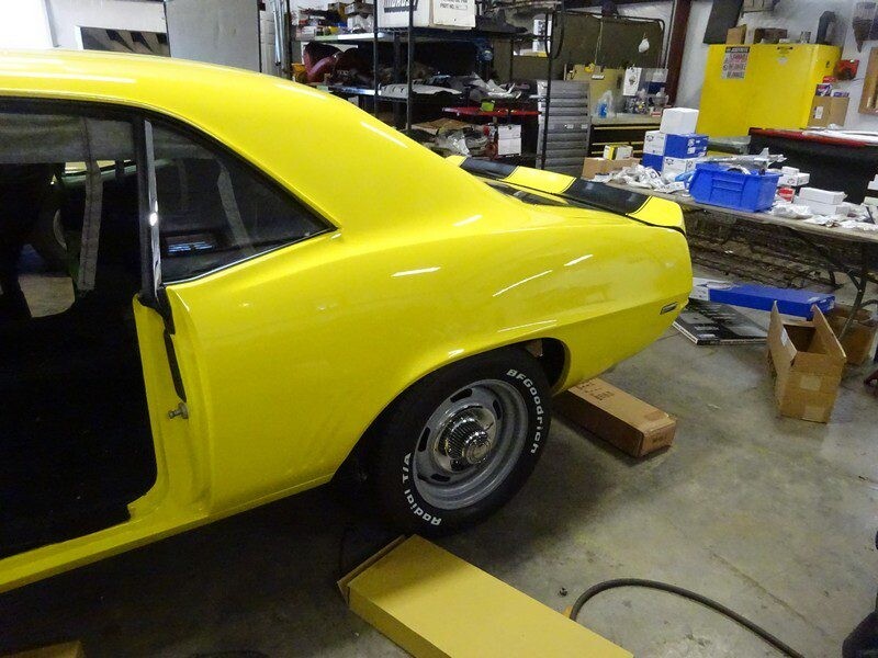 Yellow Camaro in a garage.