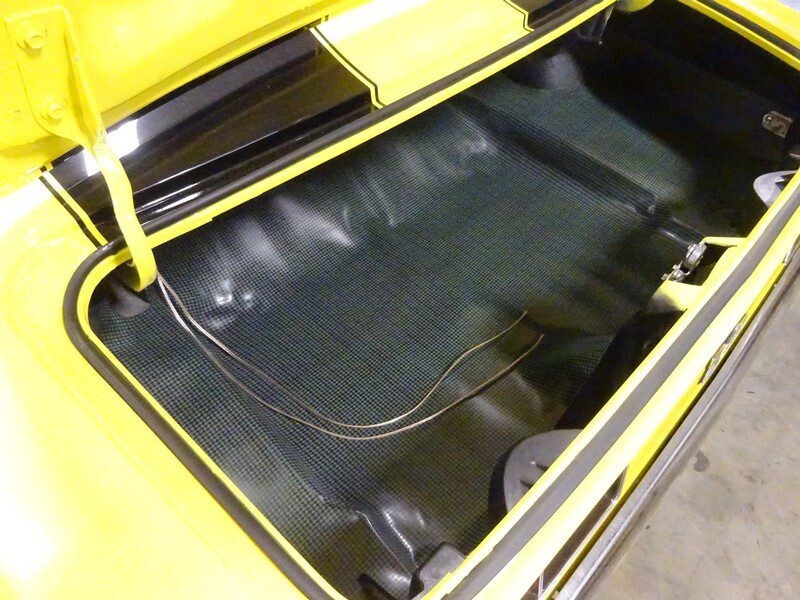 Yellow muscle car trunk interior.