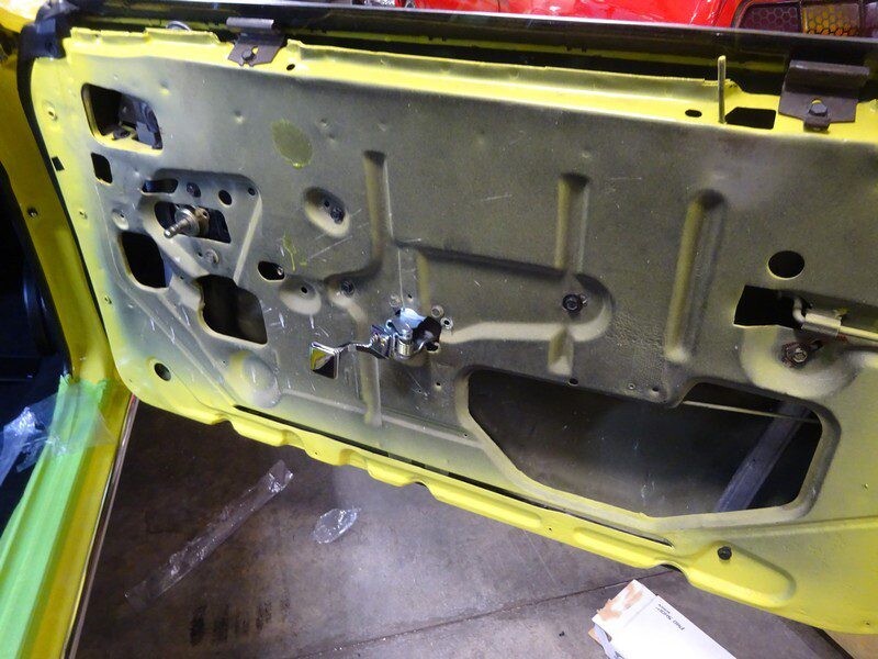 Yellow car door panel, partially assembled.