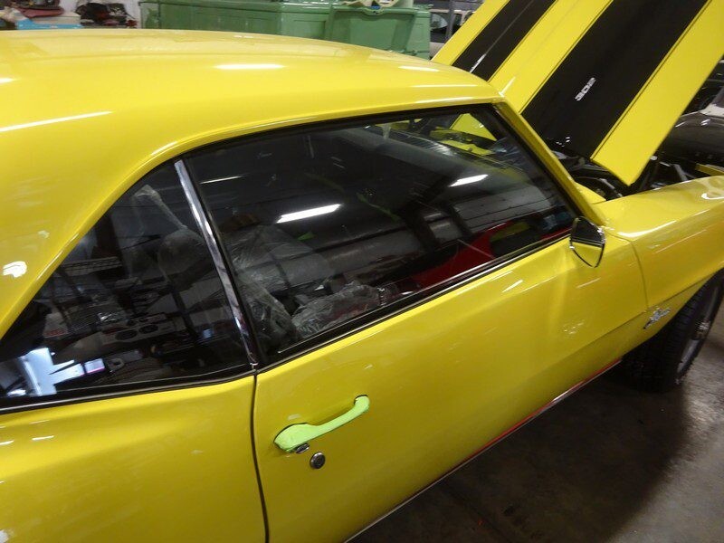 Yellow classic Camaro, side view.