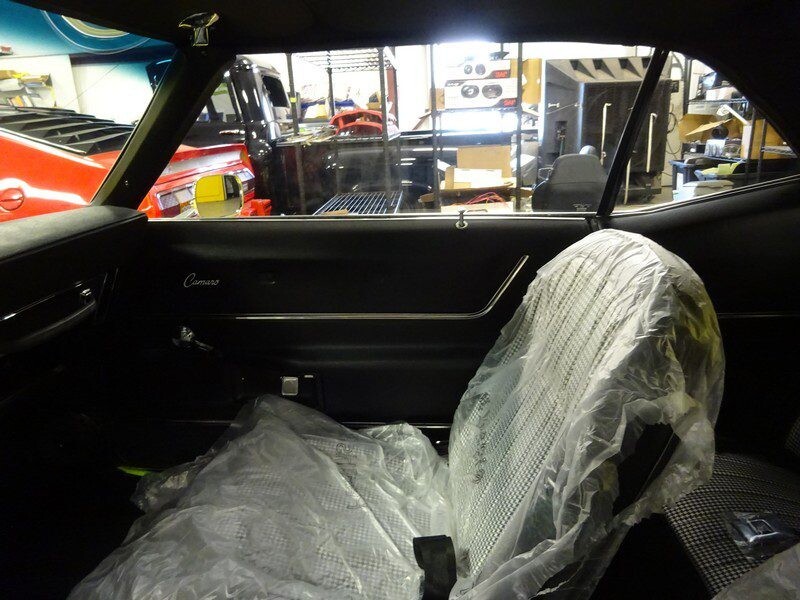 Black Camaro interior, covered seats.