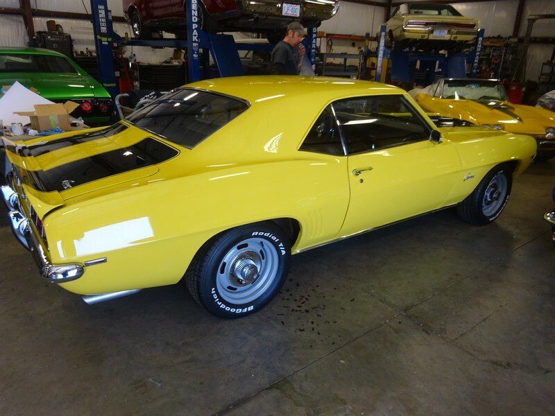 Yellow Camaro classic car in garage.