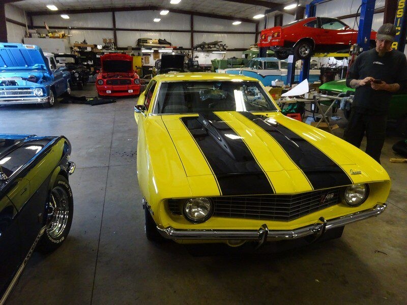 Yellow Camaro with black stripes in garage.