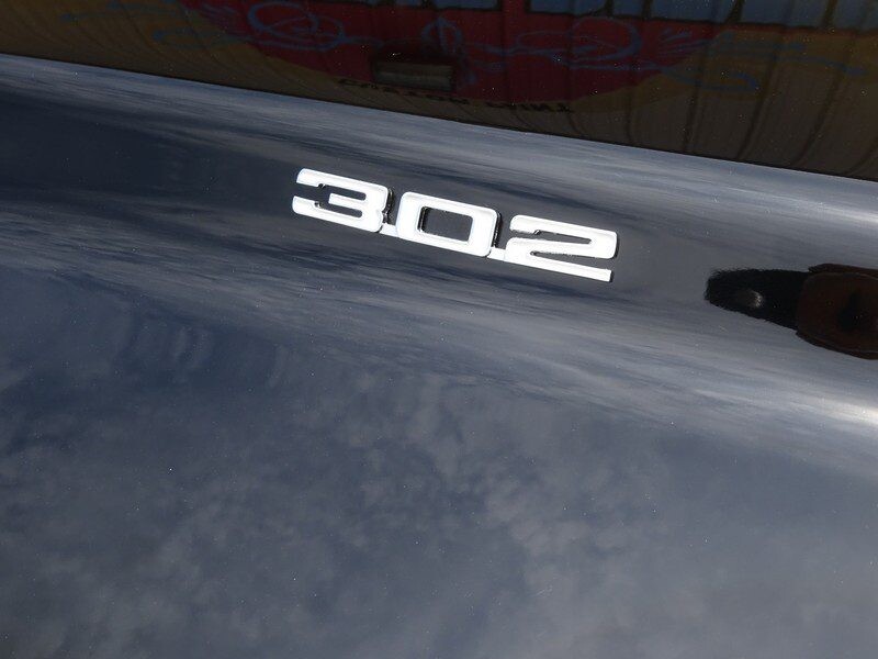 Here's an alt tag for the image: 302 cubic inch engine badge.