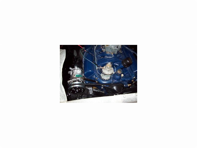 Here's an alt tag for the image: `Vintage blue car engine detail`