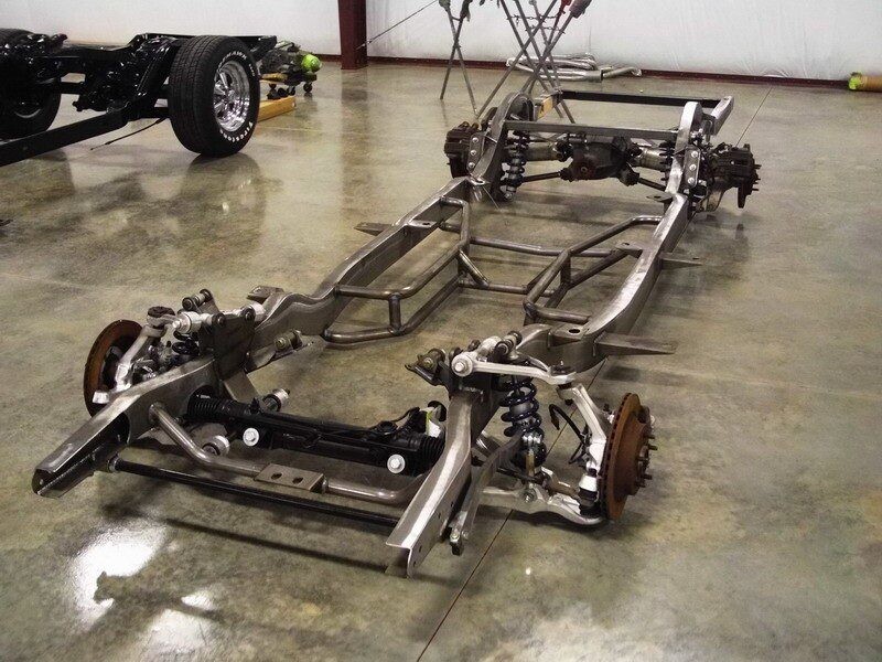 Custom car chassis frame on floor.