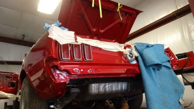 Red classic Mustang under repair.