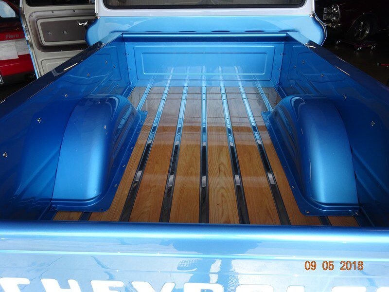Blue truck bed with wood floor.