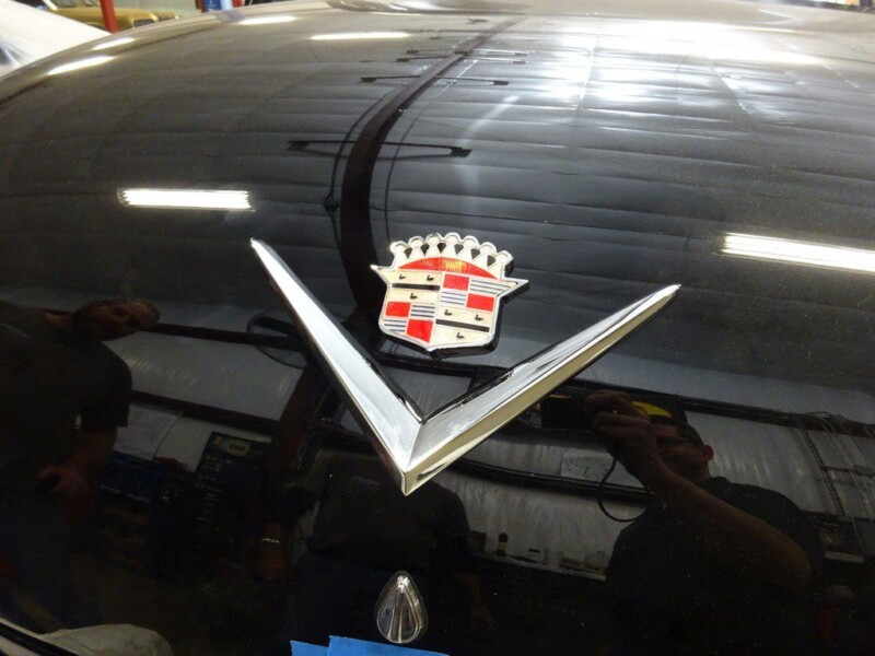 Cadillac emblem on black car hood.