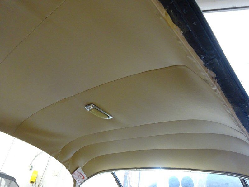 Beige car headliner with overhead light.
