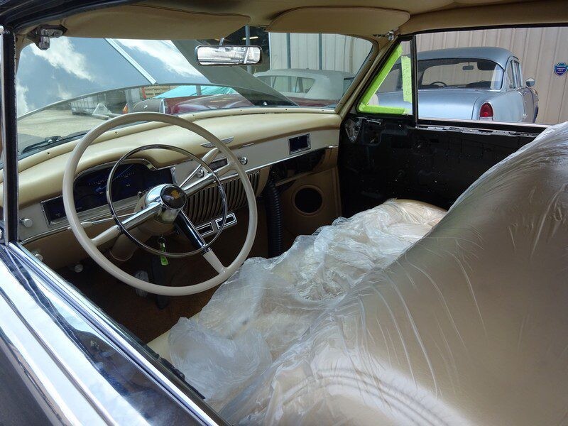 Classic car interior under plastic wrap.