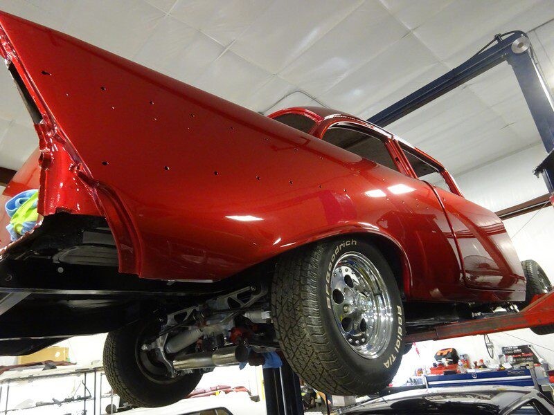 Red 1955 Chevy custom car in shop.