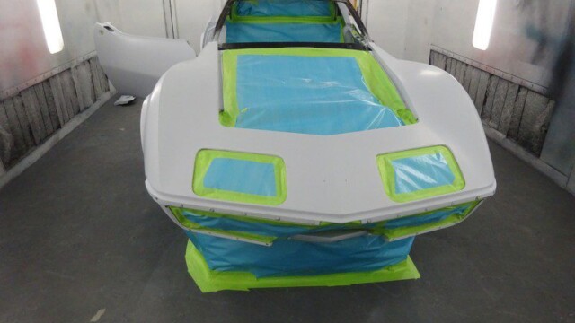 White Corvette in paint booth.