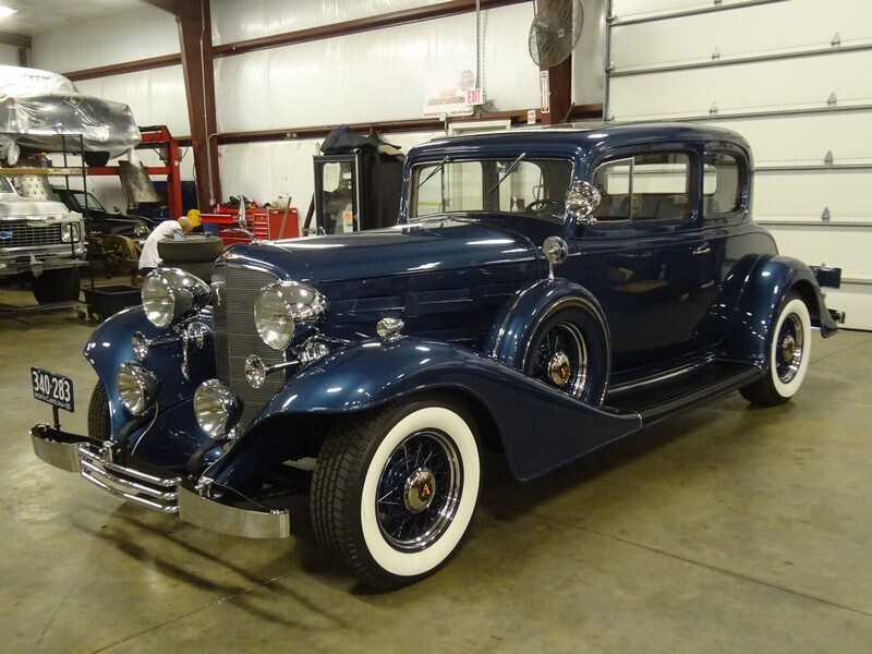 Here's an alt tag for the image: Vintage blue Cadillac coupe.