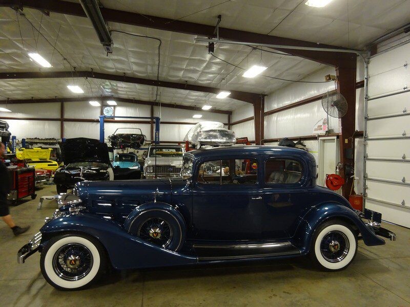 Dark blue classic car in garage.