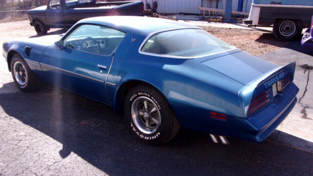 Blue Pontiac Trans Am parked outdoors.