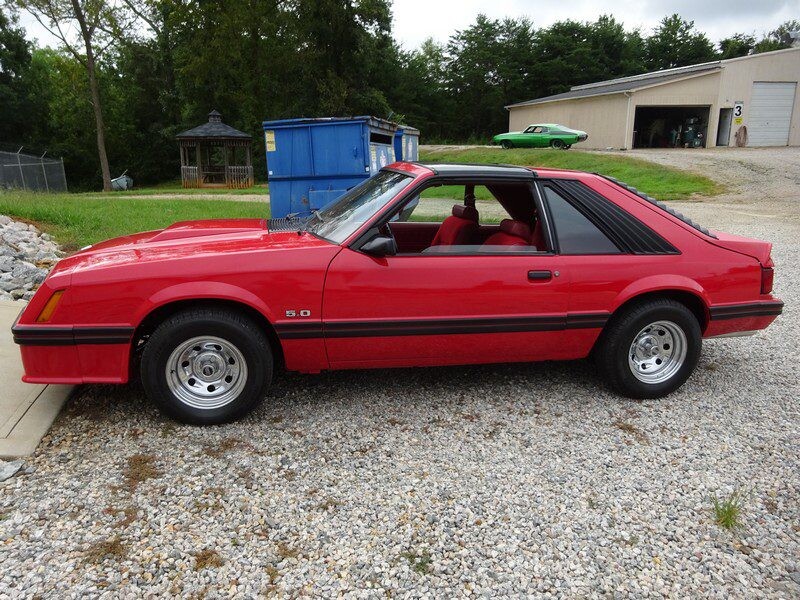 Red 1980s Ford Mustang 5.0 coupe.