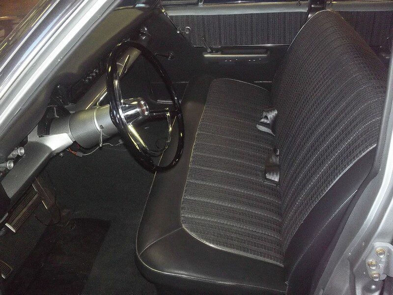 Classic car interior: steering wheel and seat.