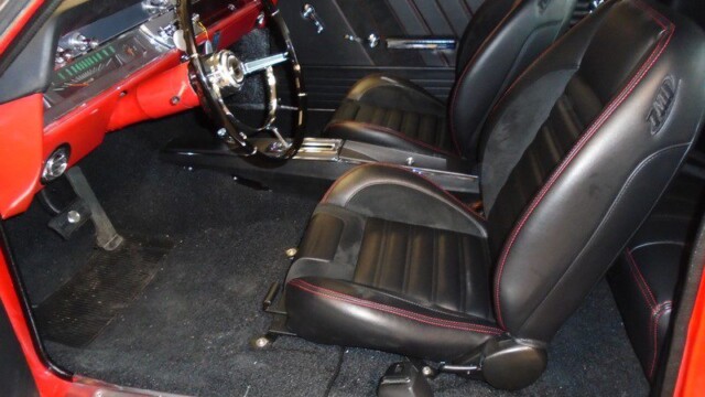 Red classic car interior, black leather seats.
