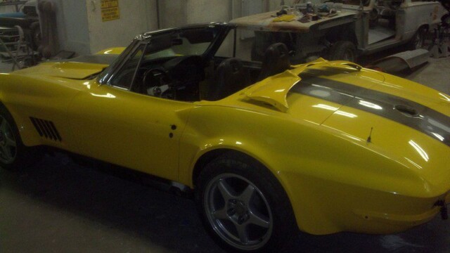 Yellow Corvette convertible in auto shop.
